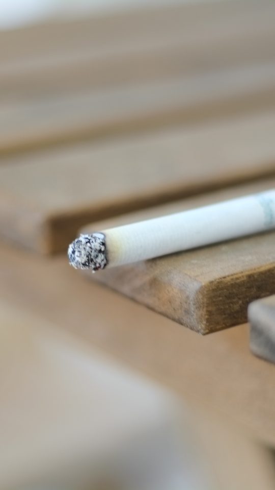a cigarette sitting on top of a wooden bench