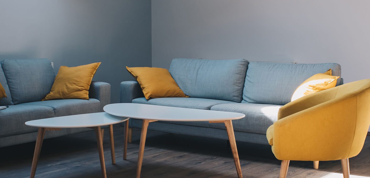 a living room with yellow and blue furniture at The Discovery Park Life Apartments