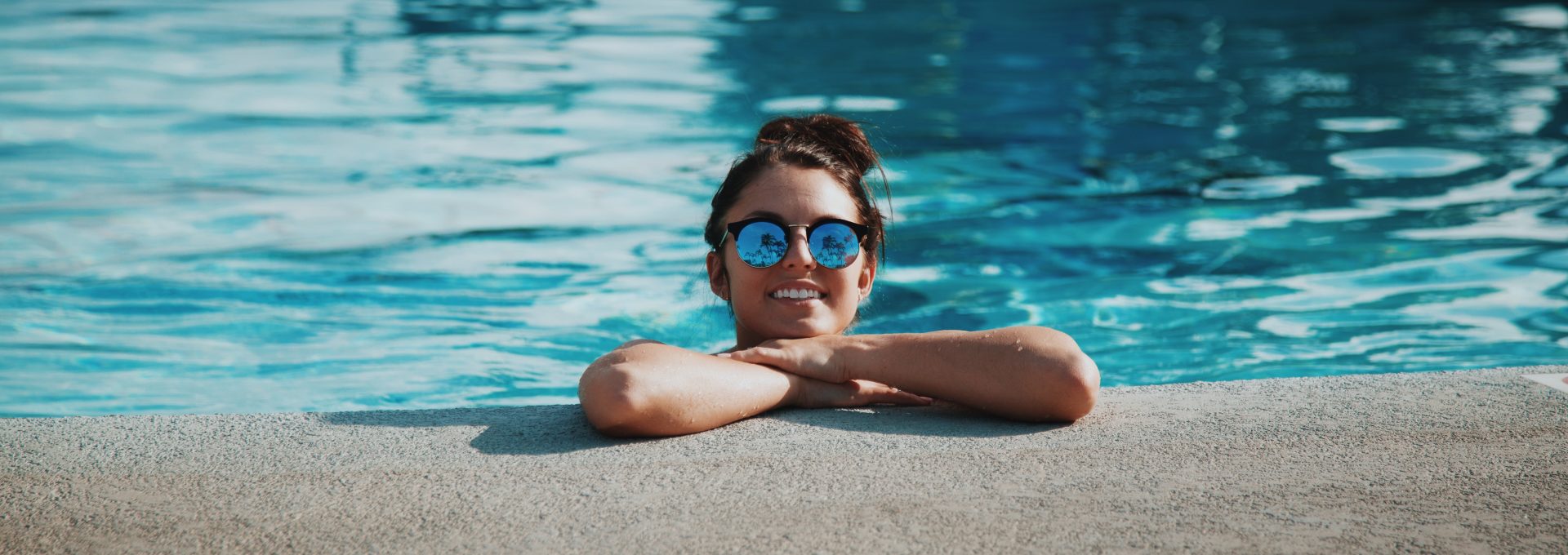 woman wearing sunglasses on swimming pool during daytime
