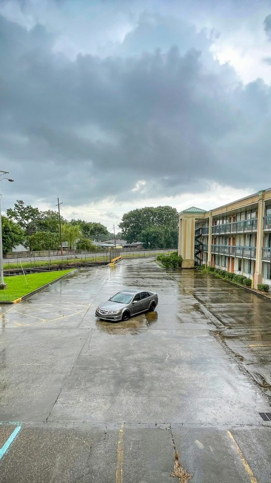 a car parked in a parking lot next to a building