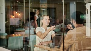 a woman and man are sitting at a table in a restaurant at The Discovery Park Life Apartments