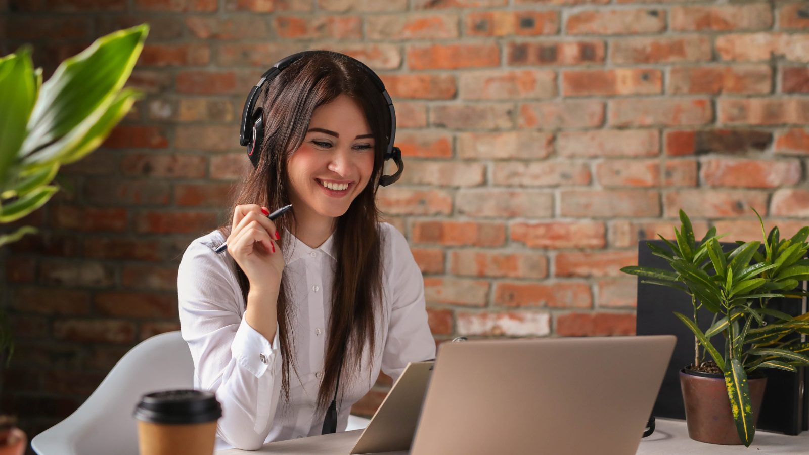 a woman is smiling while working on her laptop at The Discovery Park Life Apartments